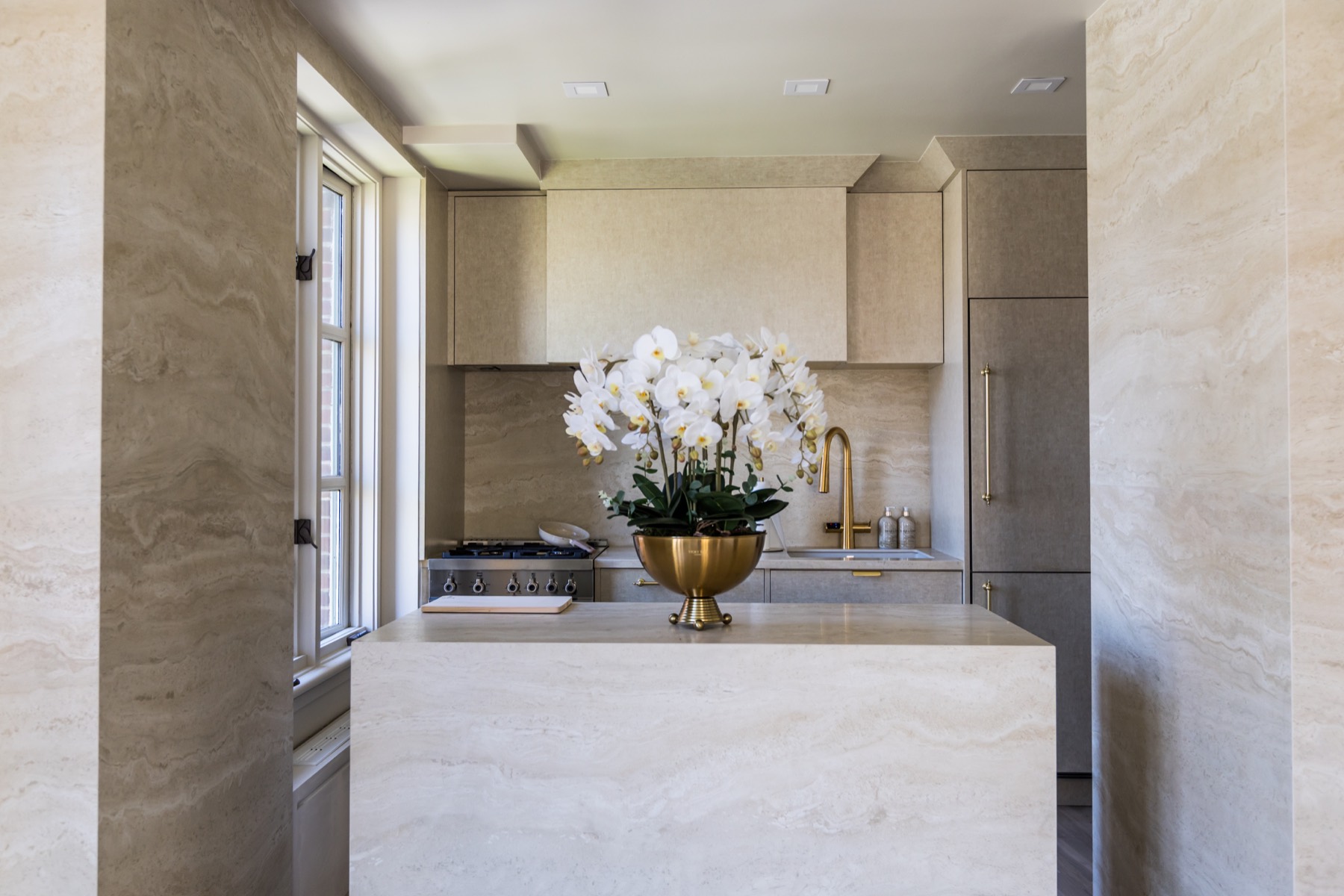 126 Waverly Place full remodeling project with a travertine kitchen island, stone-wrapped walls, and custom cabinetry in Manhattan